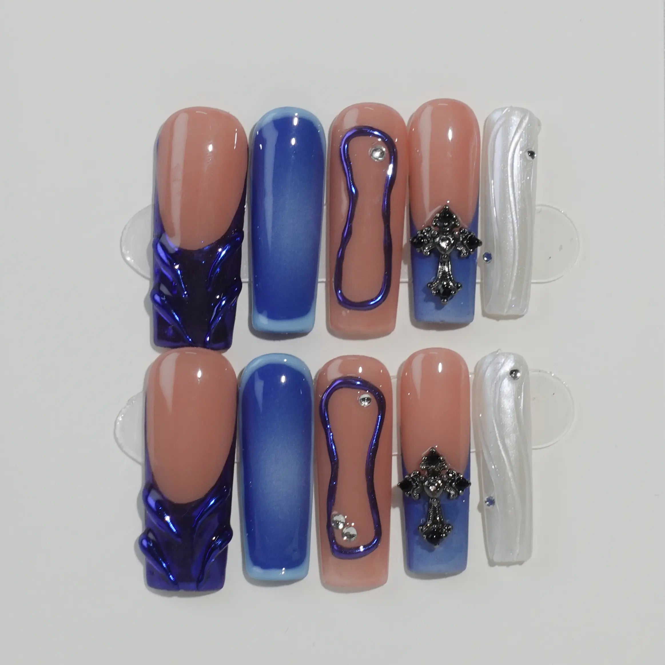 Blue coffin press on nails with ombré sea tones, gold foils, and gemstone details for summer nail styling.