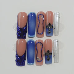 Blue coffin press on nails with ombré sea tones, gold foils, and gemstone details for summer nail styling.