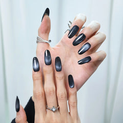 Bold onyx press-on nails styled with rings for edgy glam look