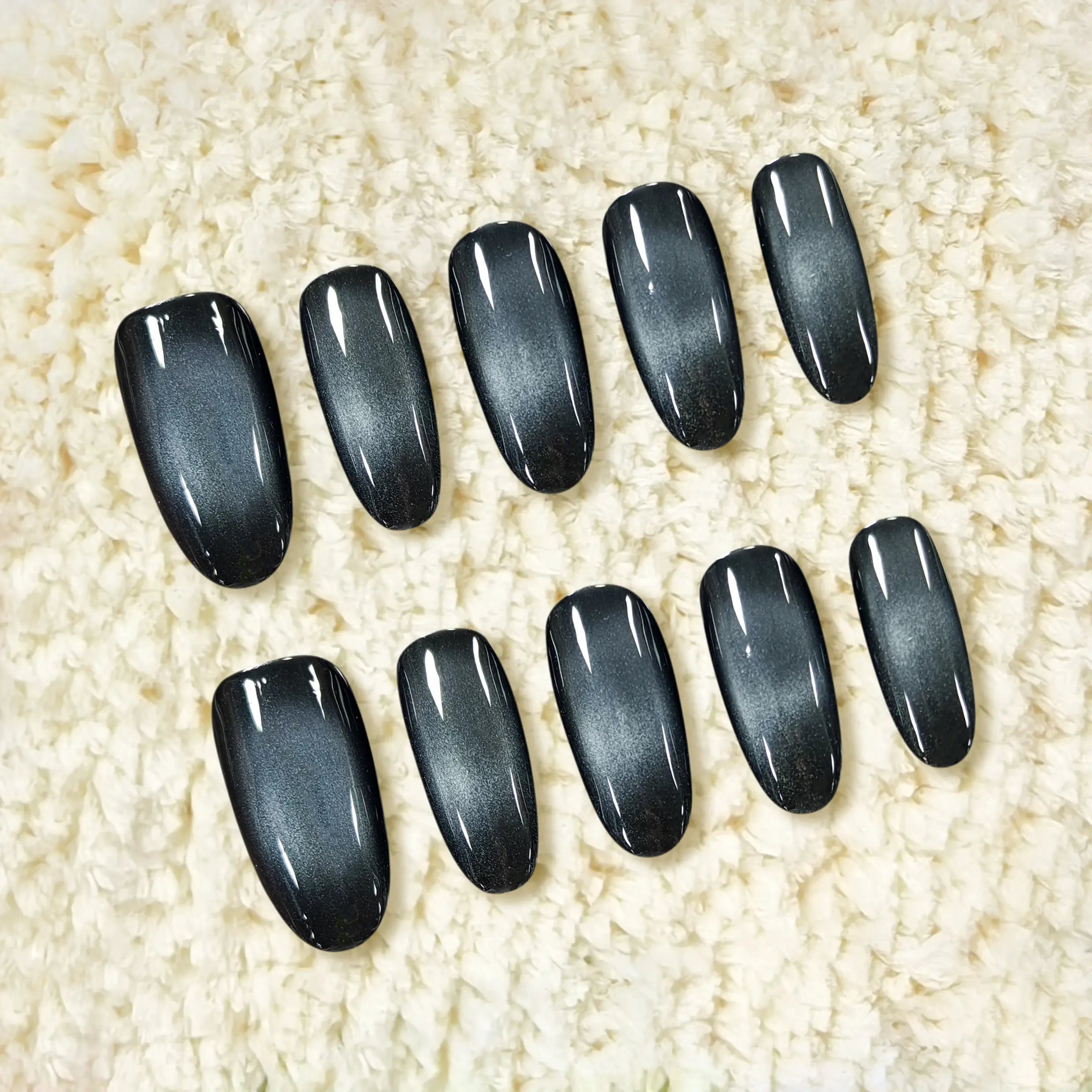 Texture-focused image of onyx gleam nails on soft fabric