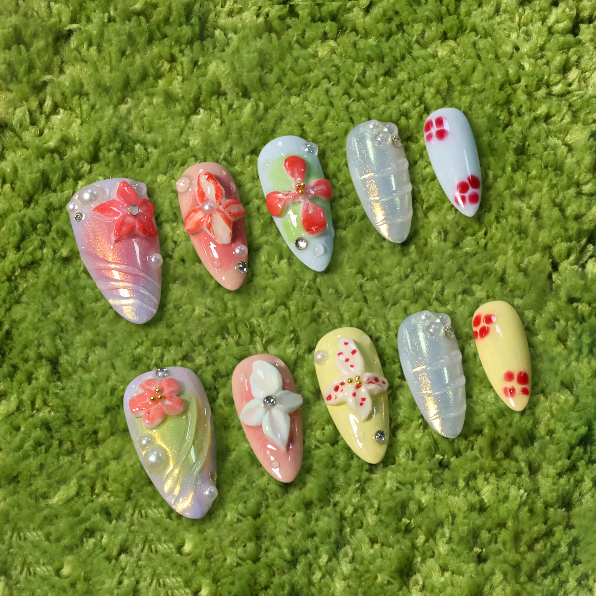 Soft pastel almond-shaped press-on nails with 3D pink flowers and pearl details, ideal for spring or romantic summer looks.