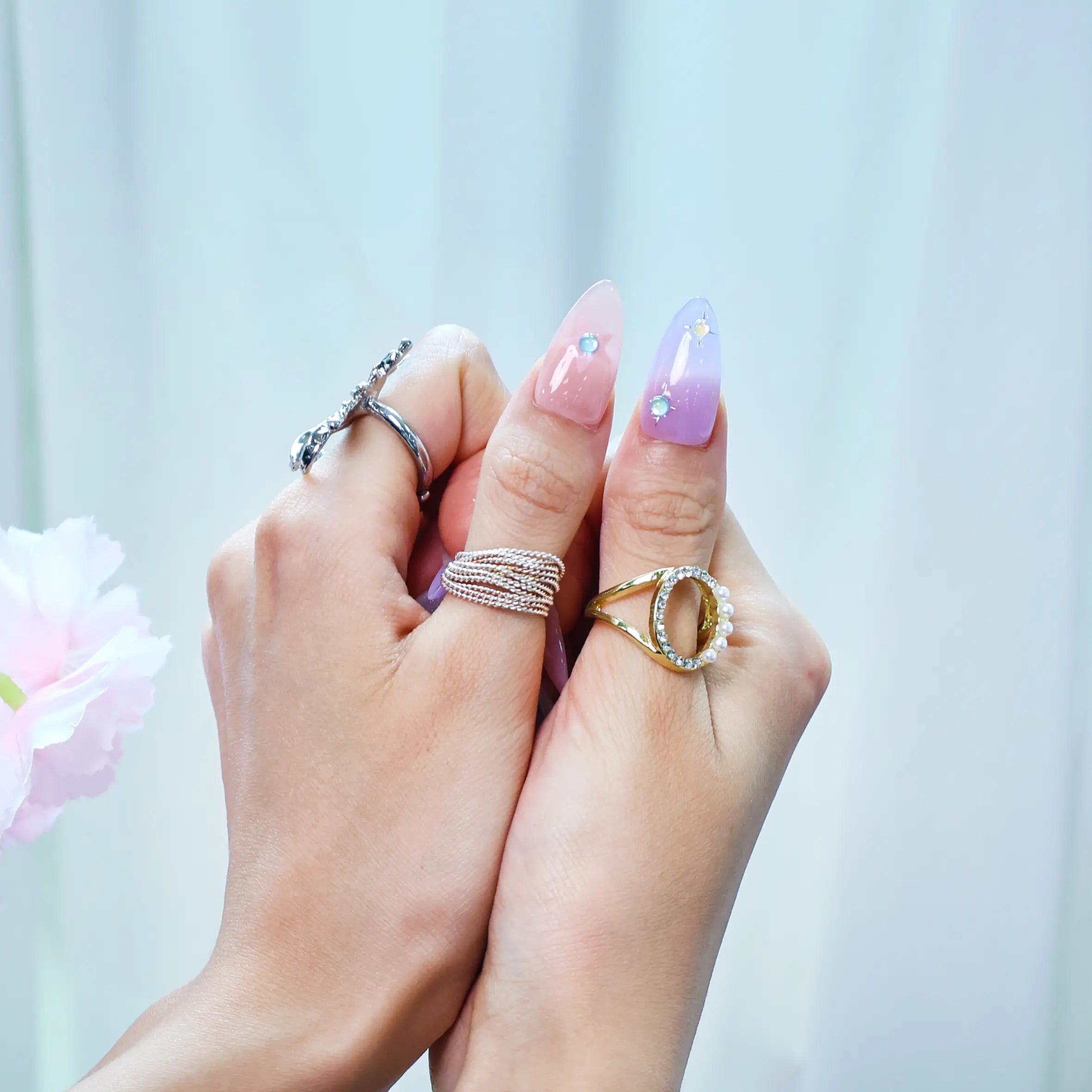 Side view of almond-shaped press-ons featuring dreamy pastel stars, lilac-pink blend, and silver accents