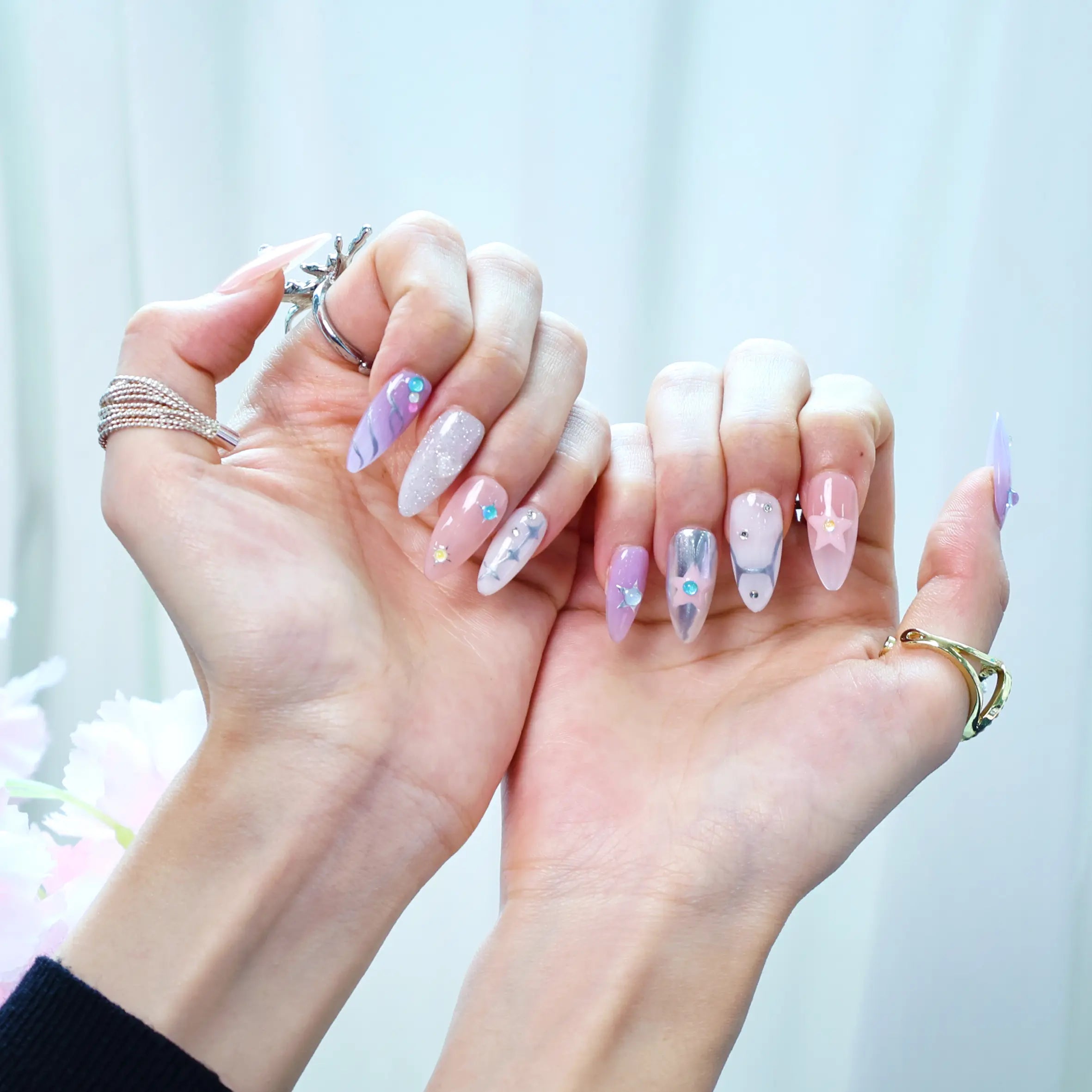 Press-on manicure with shimmering rhinestones, chrome texture, and a celestial-inspired star design