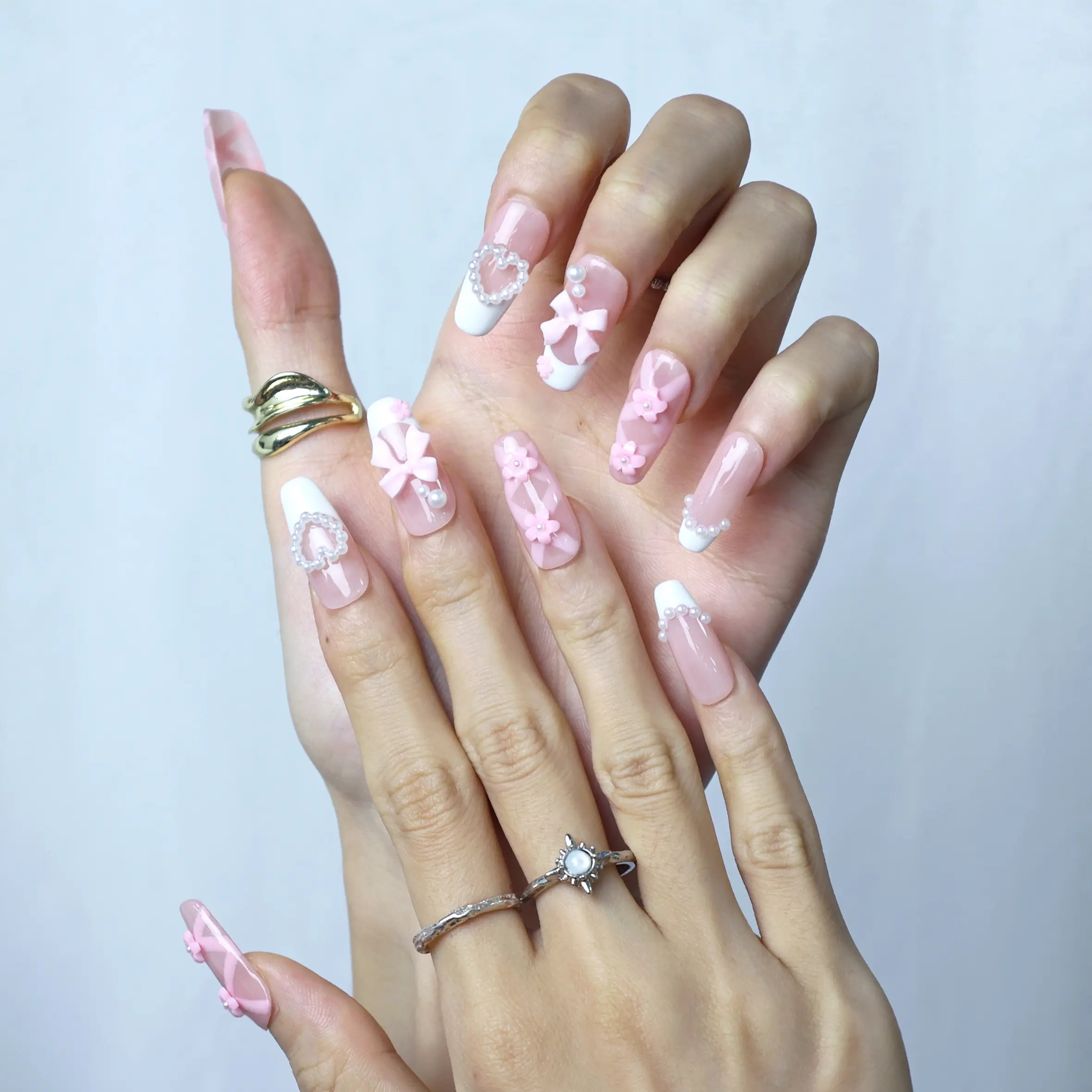 Feminine press-on nails in coffin shape with layered flower appliqués and shimmering pearls