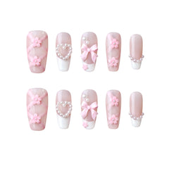 Pink coffin press on nails featuring 3D floral accents and pearl embellishments.