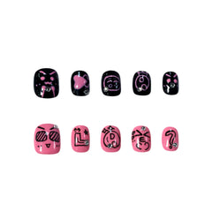 Short squoval pink and black press on nails with emoji graphics and rhinestones, bold Gen Z design.