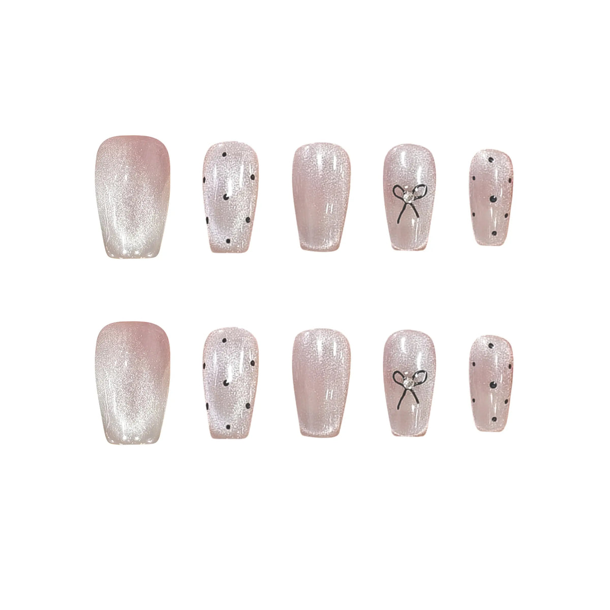 Blush pink press-on nails with black polka dots, metallic bow accent, and squoval shape for an elegant, playful look.