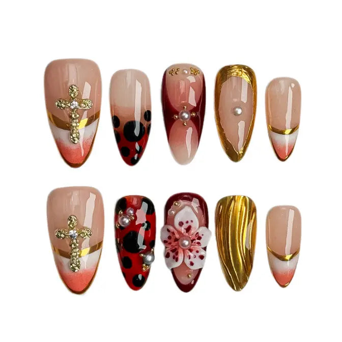 Medium almond red press on nails with gold foil accents and 3D floral designs.