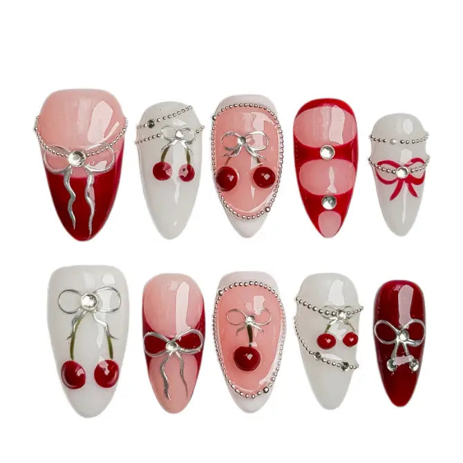 Medium red almond press on nails with cherries, white bows, and heart accents for soft girl aesthetic.