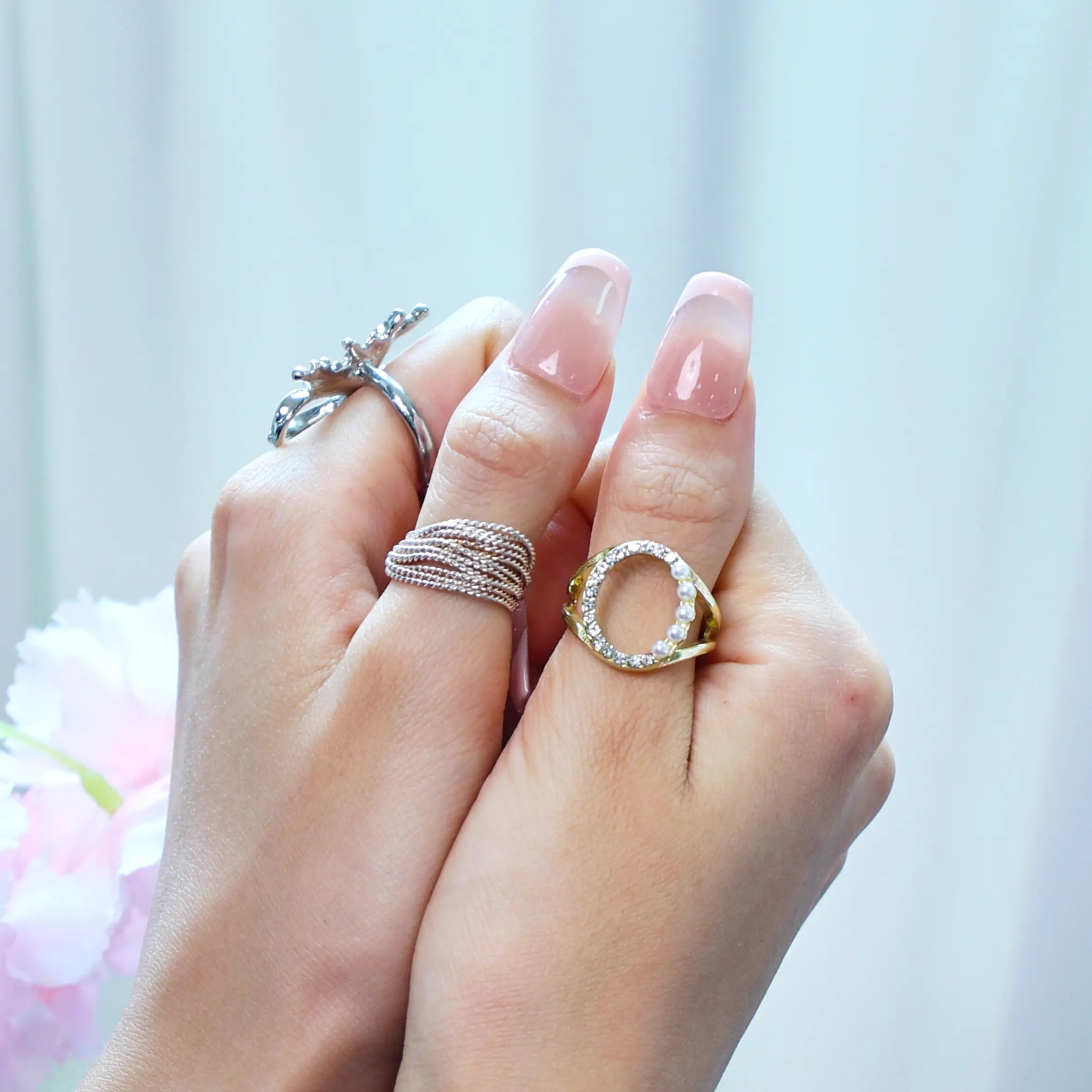 Styled hands with nude and pastel pink French nails