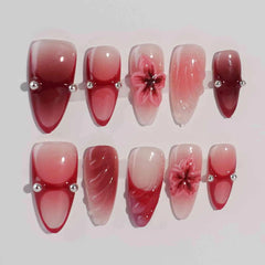 Handmade red and pink ombré almond press-on nails with glossy jelly finish and blooming 3D floral accents.