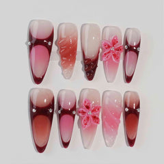 Soft pink stiletto press-on nails with sheer overlays and 3D floral accents, ideal for weddings or romantic summer looks.