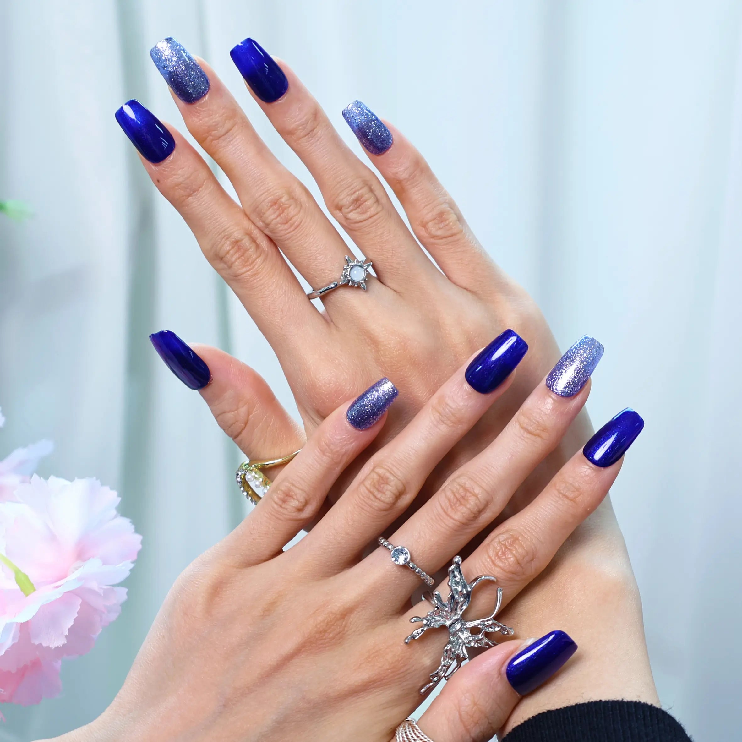 Glossy squoval nails with gradient silver glitter on deep blue base