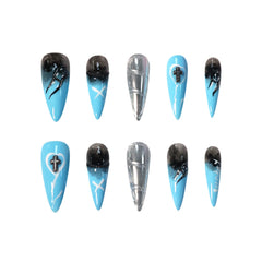 Long stiletto press-on nails with a sapphire blue to black gradient, chrome silver accents, and gothic cross charms.