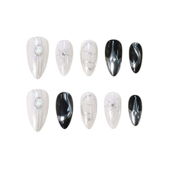 Almond press on nails in black, silver, and white with chrome accents and rhinestone detailing, inspired by lunar eclipse aesthetics.