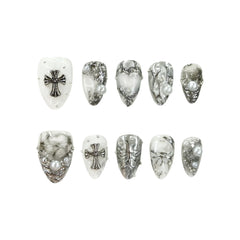 Gothic-inspired short almond press-on nails featuring milky white and smoky marble base with silver crosses and pearl embellishments.