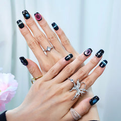 Hand close-up of magnetic black press-ons with starscape design
