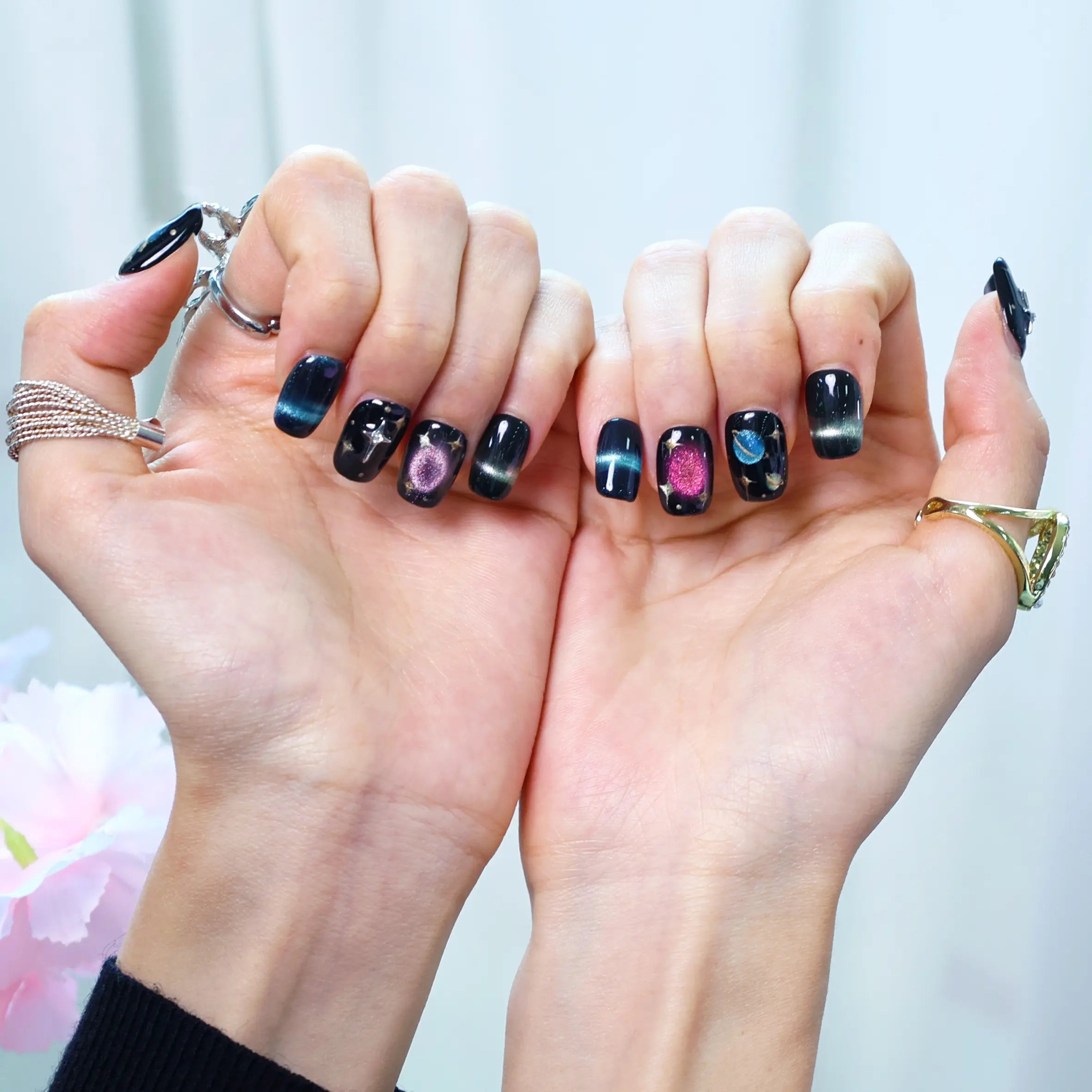 Styled shot of hands wearing galaxy press-ons with rings