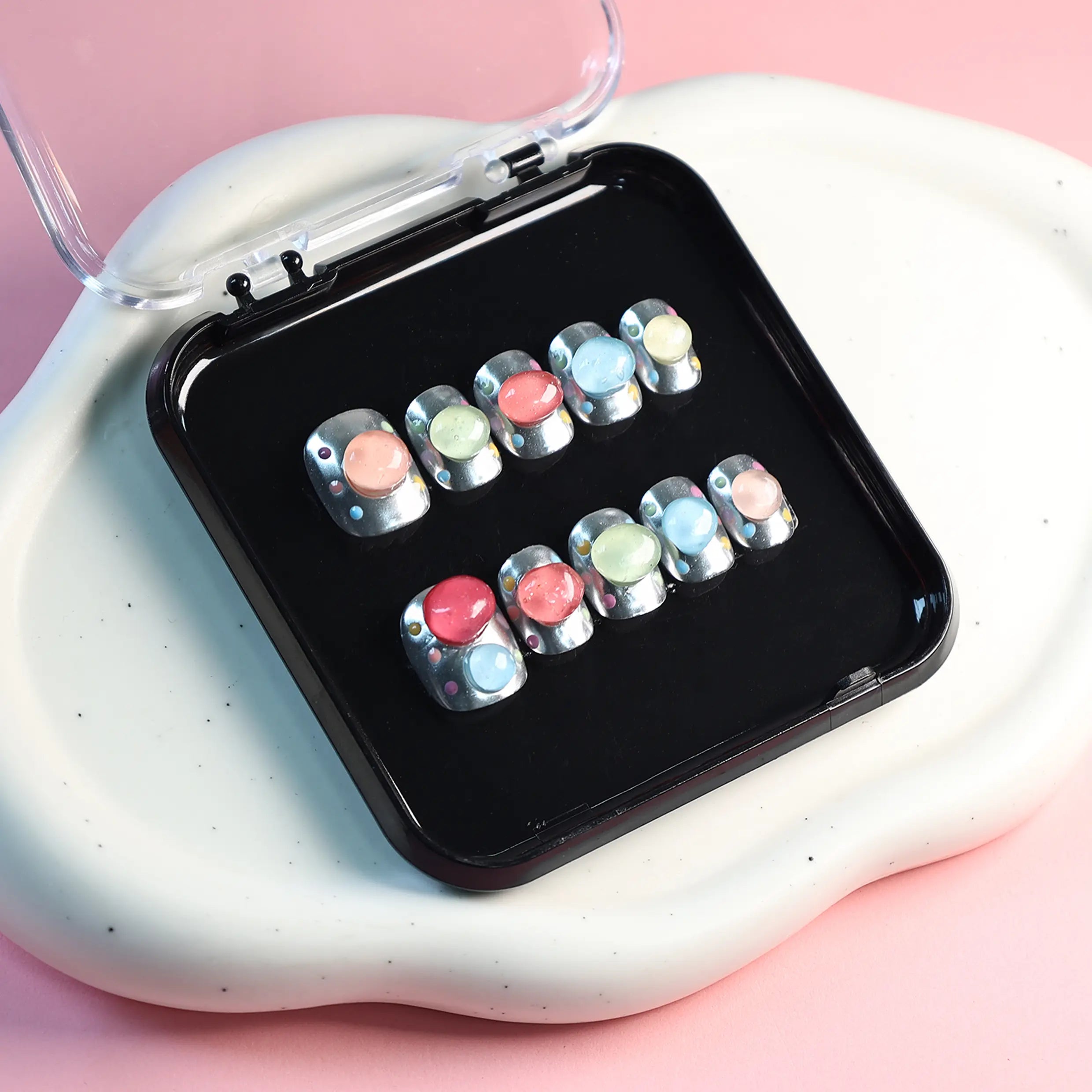Short squoval press on nails with chrome silver base and 3D jelly bubbles in pastel pink, blue, and yellow for a playful summer look