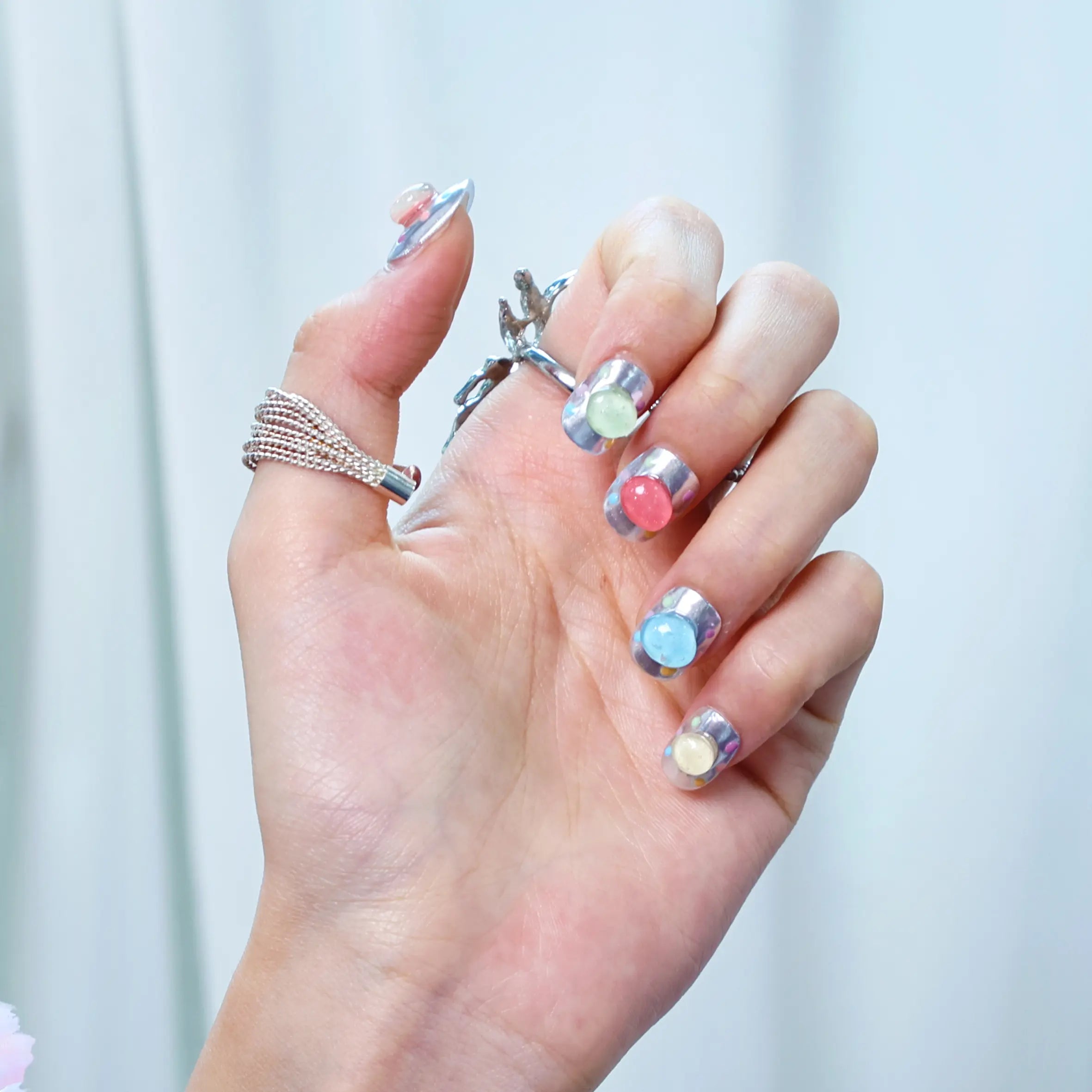 Squoval nails with shiny chrome base and playful 3D bubbles