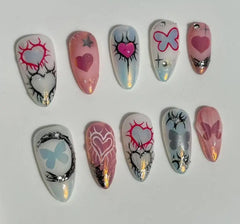 Chrome-finish pink almond press on nails with candy heart details and glitter edges.