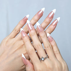 Hand model wearing nude and white French tip nails in a timeless, glossy finish