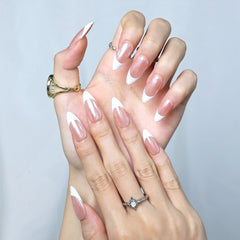 Classic French press-on nails with soft nude base and sharp white tips, styled on hand