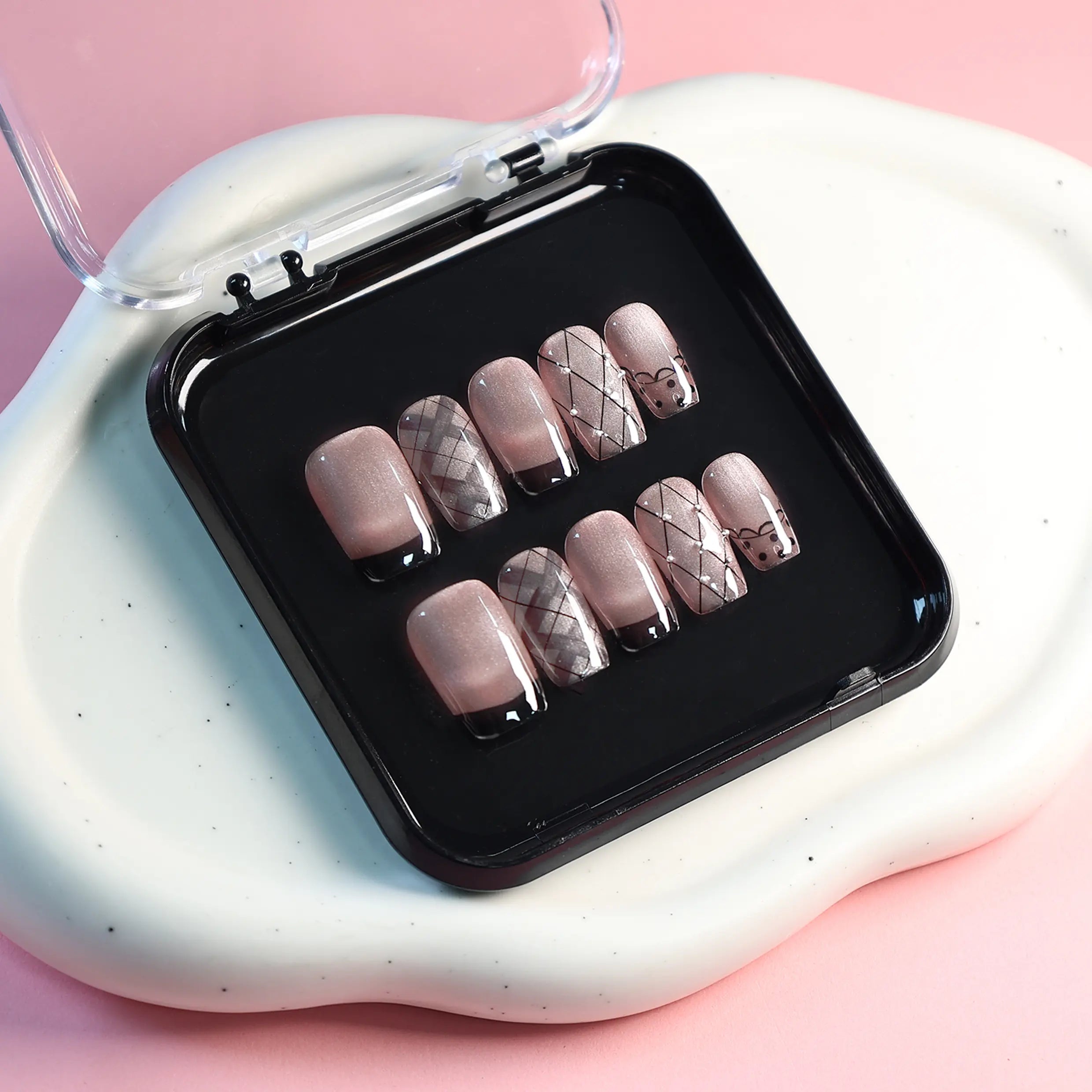 Display of pink press-on nails on white tray for product detail