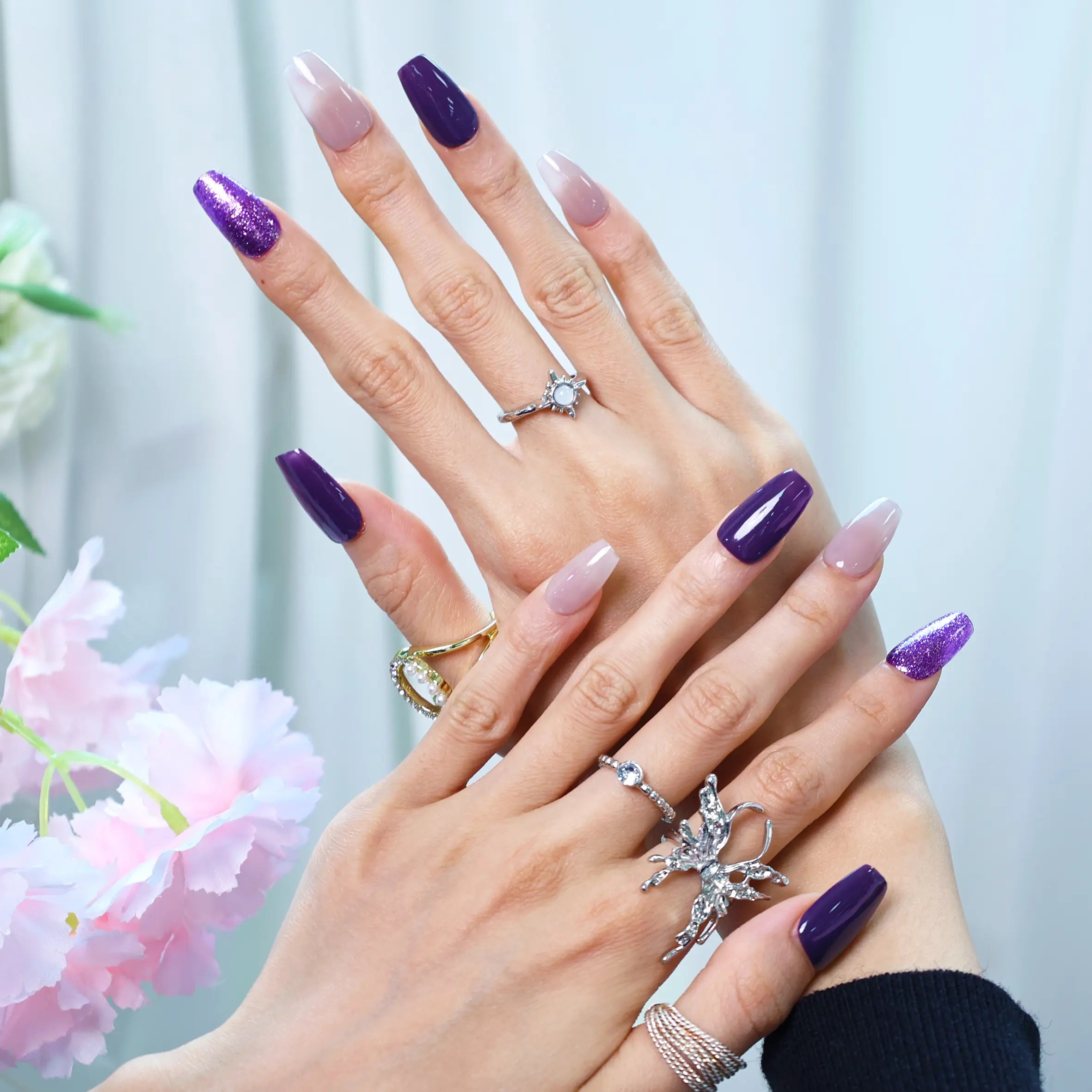 Hand pose showing glossy purple ombré nails with nude base
