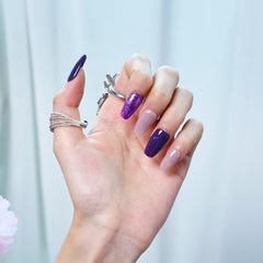 Handmade purple press-on nails with squoval shape shown from side angle