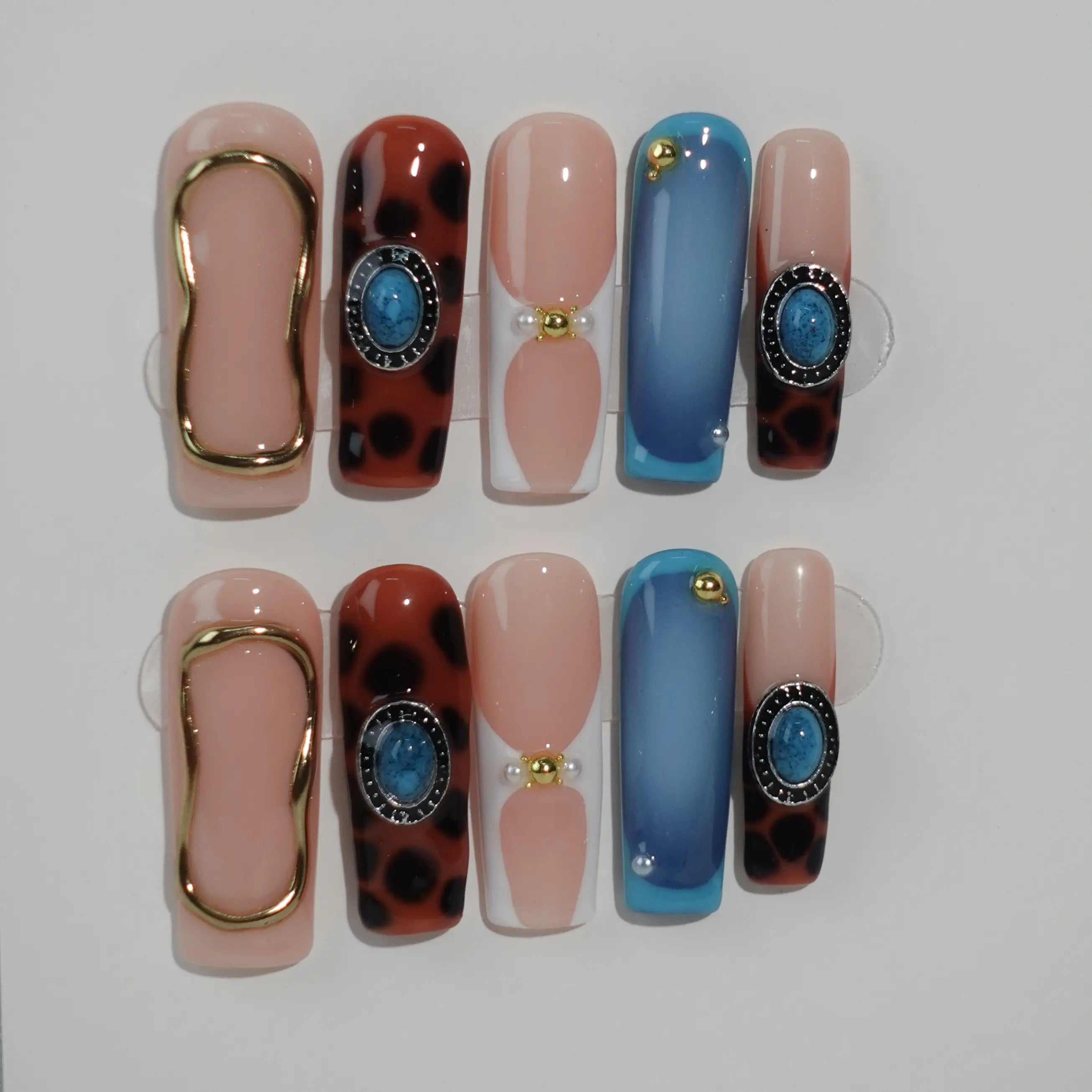 Coffin press on nails with leopard print, rose gold accents, and nude base—perfect for bold summer nail looks.