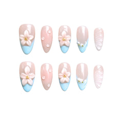 Medium almond press-on nails in pastel pink and blue gradient, with 3D floral decorations and pearls, perfect for spring and summer.