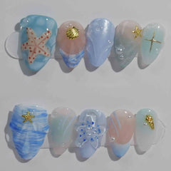 Handmade medium almond press-on nails in jellyfish blue with seashell textures and gold starfish, perfect for summer beach vibes.